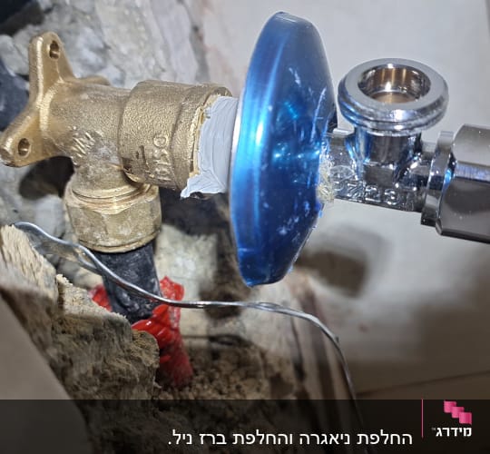 שסתום מתכת עם חיבורי צנרת בקיר